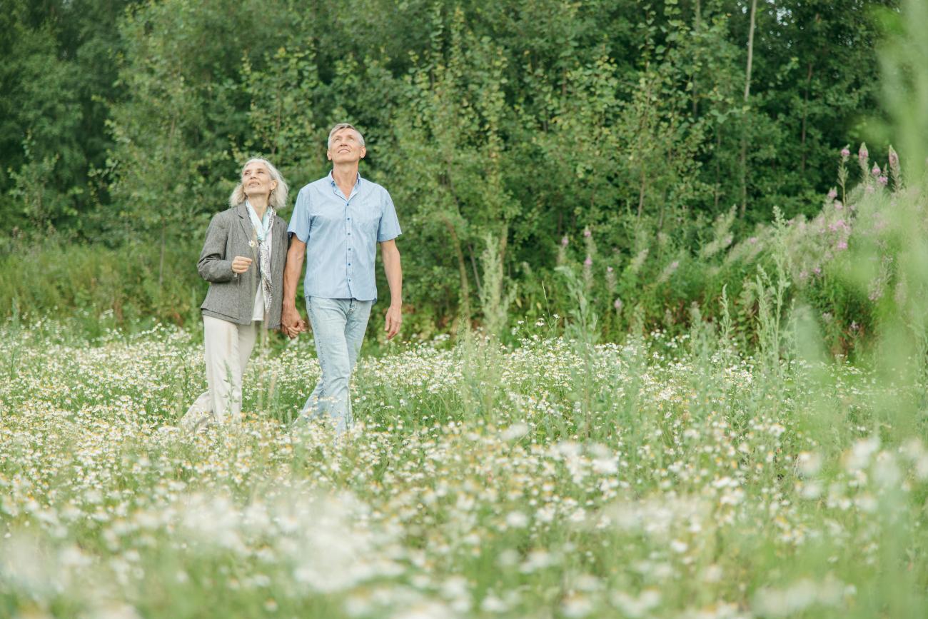 retired couple walking in the field as they think about retirement planning