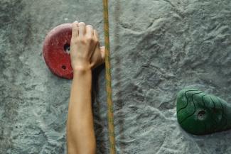 Risk in the retirement red zone illustrated by person climbing a rock wall